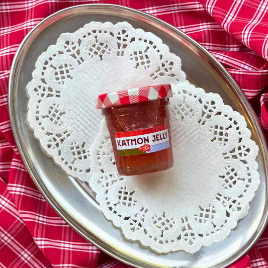 Small jar on a doily with a red checkered fabric background