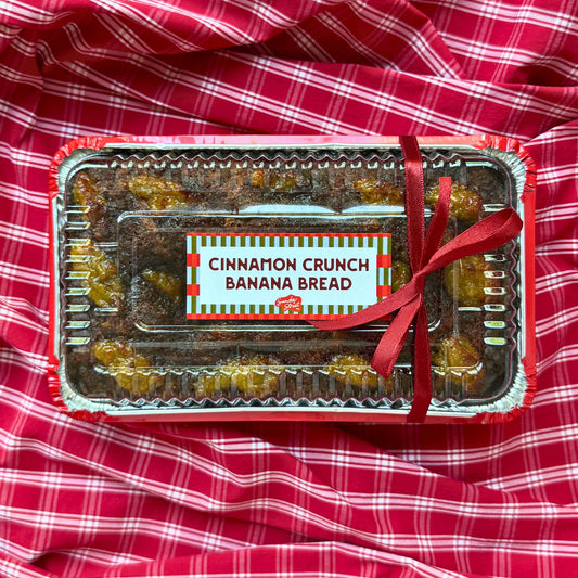 Packaged cinnamon crunch banana bread on a red checkered fabric background