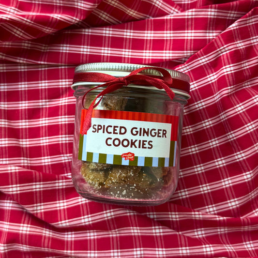 Jar of spiced ginger cookies on a red and white checkered fabric